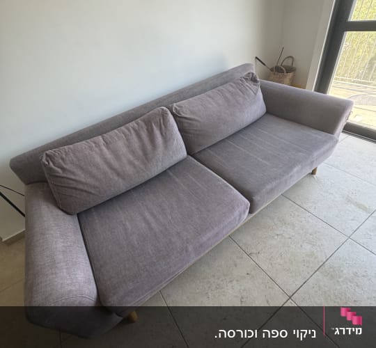 ספה אפורה בחדר עם רצפת אריחים